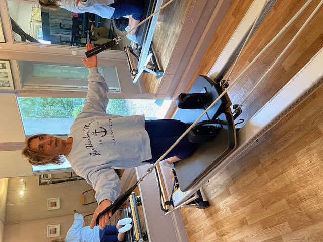 Femme en cours de Pilates sur machine Reformer